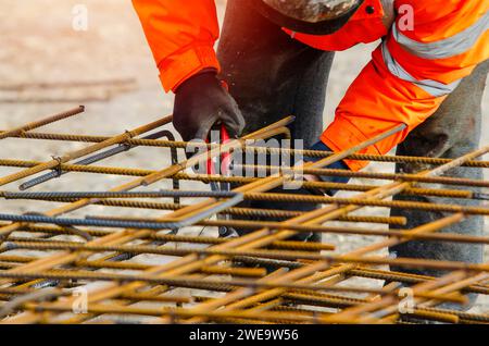 Steel fixer assembling reinforcement cage off rebars. Selective focus Stock Photo