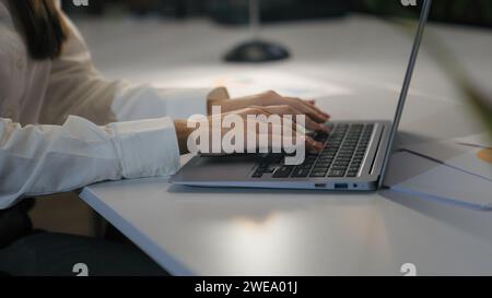 Unrecognizable woman office worker business female girl user businesswoman cropped view hands typing laptop keyboard computer working online job at Stock Photo