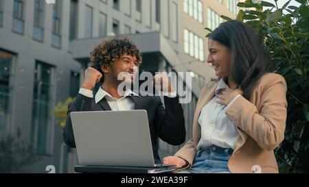 Excited happy celebrating winning Indian businessman Arabian businesswoman give high five gesture business partners colleagues people in city Stock Photo