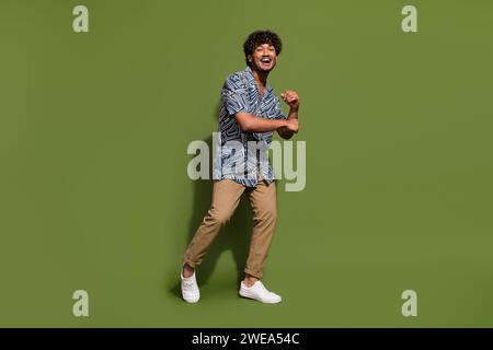 Full body size photo of american best dancer at party doing dynamic moves likes his casual apparel isolated on khaki color background Stock Photo