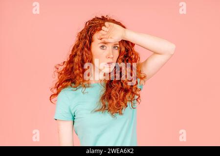 Young red hair female feeling unhealthy, strong sudden pain  touching forehead, suffering from headache. Healthcare concept. Stock Photo