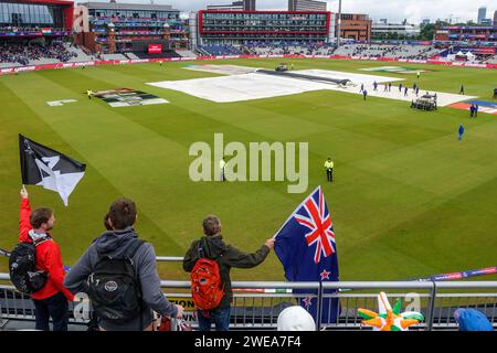 Spectators with flags watching a cricket match (New Zealand - India, semifinals) at Old Trafford stadium on a cloudy day at the Cricket world Cup 2019 Stock Photo