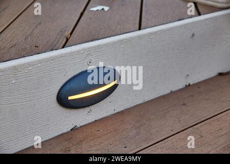 Modern Outdoor Wall Light on Wooden Siding, Warm Glow at Dusk Stock Photo