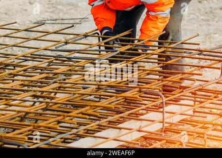 Steel fixer assembling reinforcement cage off rebars. Selective focus Stock Photo