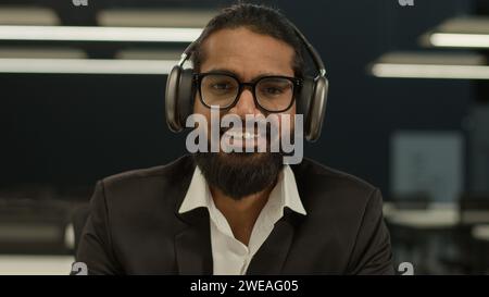 Indian man Arabian guy entrepreneur business male student intern mentor coach consultant businessman writing notes in notebook listening to music on Stock Photo