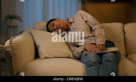 Tired exhausted African American businesswoman night working laptop from home overworked woman fall asleep on couch sick weary sleeping female flopped Stock Photo