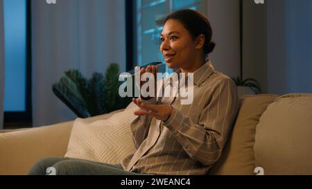 African American woman businesswoman record voice message on speaker phone send audio voicemail dictate information in microphone AI mobile assistance Stock Photo