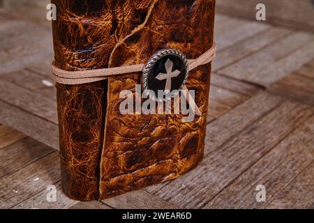 Vintage Leather Journal with Cross Emblem on Wooden Table Stock Photo
