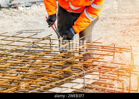 Steel fixer assembling reinforcement cage off rebars. Selective focus Stock Photo