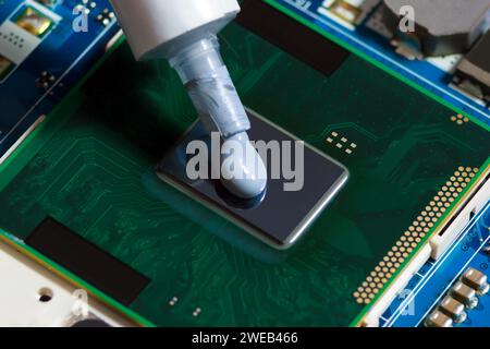 Thermal Paste Compound Squeezing On Processor Of Notebook. Thermal Grease For Better CPU Cooling. Stock Photo