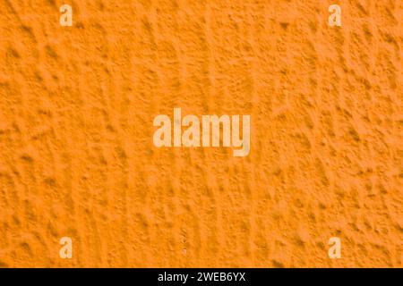 Relief texture of orange paint on the wall. Stock Photo