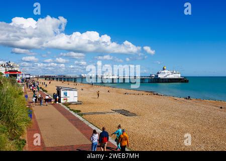 Shingle beach, promenade and view of Eastbourne Pier in Eastbourne, East Sussex, a resort town on England’s south-east coast, looking east Stock Photo
