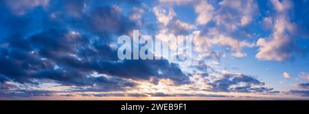 Beautiful cloudy sky with the setting sun. Sky panorama for background. Stock Photo