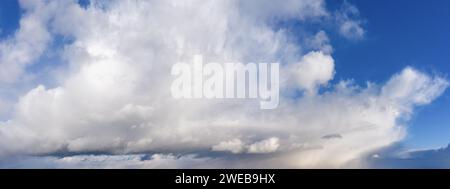 Blue sky with white fluffy clouds in daylight. Natural background. Stock Photo