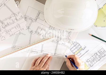 Top view of an architect hands working on Architecture plans on desk Stock Photo