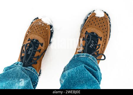 Close up of man with work boots standing in the snow feet only Stock Photo