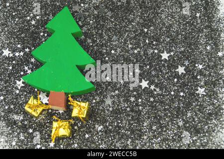 wooden decorative Christmas tree and small golden presents on scattered stars Stock Photo