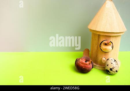 two toy birds and a real egg in front of a bird house Stock Photo