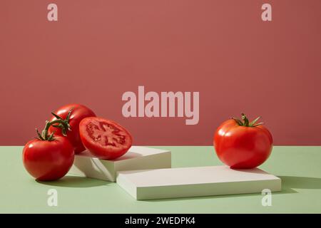 Cylinder white podiums decorated with ripe fresh tomatoes on pink background. Minimal empty display product presentation scene. Summer fruit concept. Stock Photo
