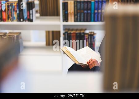 Close-up of person reading a book in the library. Studying in the library. High quality photo Stock Photo