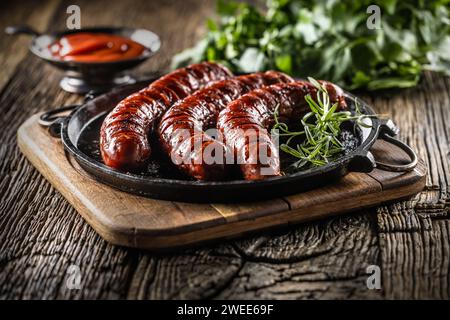 Sausages fried with spices bbq sauce and herbs - Close up. Stock Photo