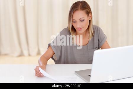 Happy woman, laptop and documents for finance, budget planning or insurance on table at home. Female person smile with paperwork or invoice for bills Stock Photo