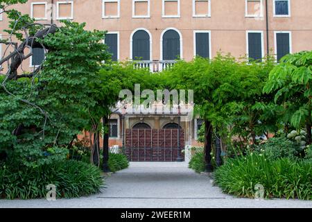a green arch made of trees in front of the entrance to the house in the Giardini Reali of Venice Stock Photo