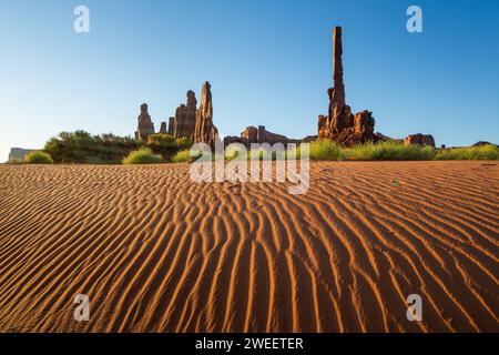 The Totem Pole & Yei Bi Chei with rippled sand dunes in the Monument Valley Navajo Tribal Park in Arizona. Stock Photo