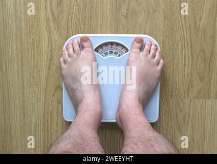 Man's Feet On Bathroom Scales As He Weighs Himself Stock Photo