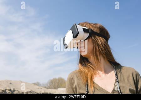 young woman wearing virtual reality goggles outdoors Stock Photo