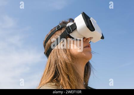 young woman wearing virtual reality goggles outdoors Stock Photo