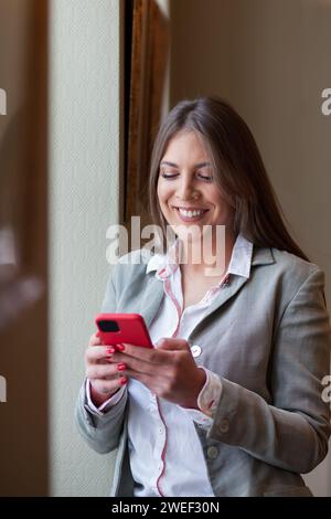 young woman smiling while using her mobile phone Stock Photo