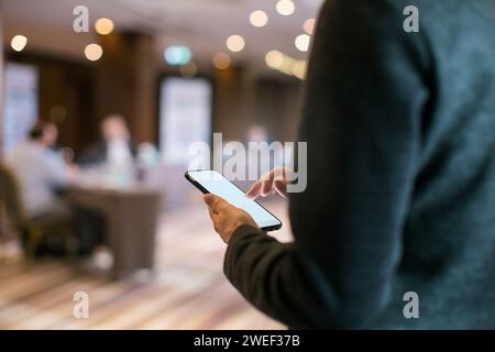 woman taking notes on mobile phone during a conference Stock Photo