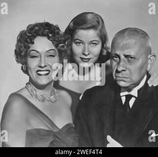 Gloria Swanson, Erich von Stroheim, and Nancy Olson star in 'Sunset Boulevard' (1950), a classic film noir directed by Billy Wilder. Swanson delivers a legendary performance as Norma Desmond, a faded silent film star living in delusion, while von Stroheim portrays Max von Mayerling, her devoted butler and former husband. Olson plays Betty Schaefer, an aspiring screenwriter who becomes involved with Joe Gillis, played by William Holden. Stock Photo