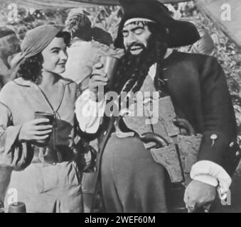 Jean Peters and Thomas Gomez star in 'Anne of the Indies' (1951), a swashbuckling adventure film. In this movie, Peters portrays the fiery Captain Anne Providence, a female pirate commanding her ship in the Caribbean. Thomas Gomez plays Blackbeard, a notorious pirate who is both an ally and a mentor to Anne. The film revolves around Anne's battles on the high seas, her encounters with the British Navy, and a complex love story that challenges her hardened exterior. Stock Photo