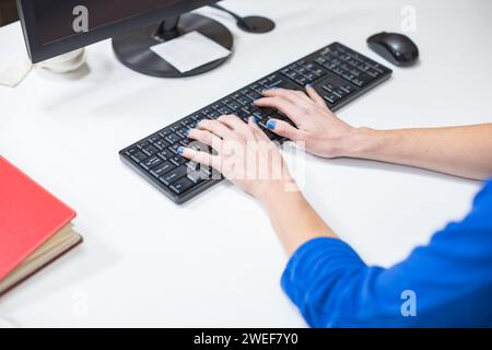 close up of woman's hands typing on a keyboard Stock Photo