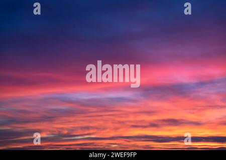 Glowing real sky at sunset texture background overlay. Dramatic red, orange, and purple clouds. High resolution photography perfect for sky replacemen Stock Photo