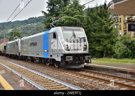 Two Captrain Italia Bombardier TRAXX DC3 class E.494 electric locomotives pass Stresa station with a northbound freight train. Stock Photo