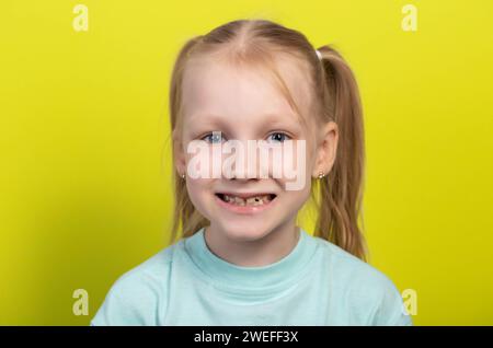 Portrait of a smiling seven-year-old girl with growing molars and falling out baby teeth. Defects of crooked teeth in the oral cavity. Children's dent Stock Photo