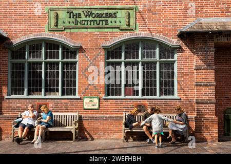 UK, England, West Midlands, Dudley, Black Country Museum, visitors sat in sunshine outside Worker’s Institute Stock Photo