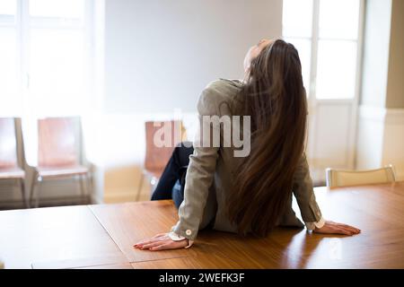 back view of businesswoman sitting on her office table Stock Photo