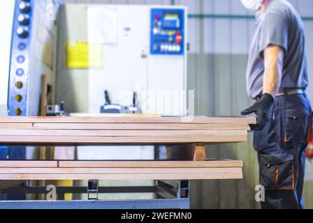 worker operating machine in wood processing factory Stock Photo