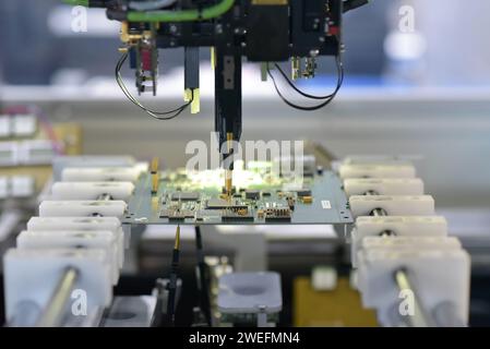 robot automatically assembles circuit board with electronic components in a modern factory Stock Photo