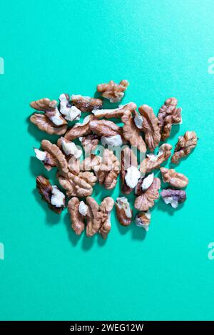 crashed walnuts isolated on green background Stock Photo