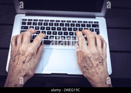 old persons hands on laptop keyboard Stock Photo