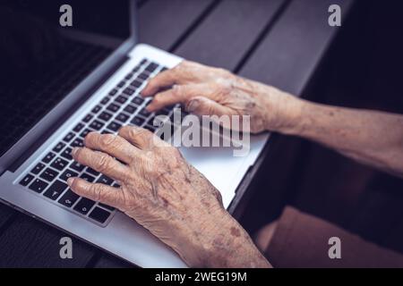 old persons hands on computer keyboard Stock Photo