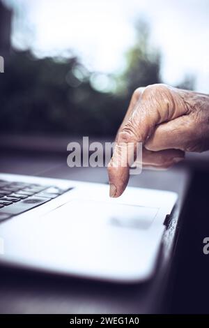 old persons finger on laptop keyboard Stock Photo