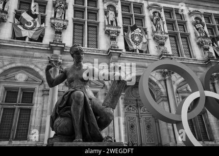 Paris, France - February 21, 2023 : Paris 2024 summer Olympic Games. Olympic rings near Hotel de Ville and woman statue. Women in sport. Black white Stock Photo