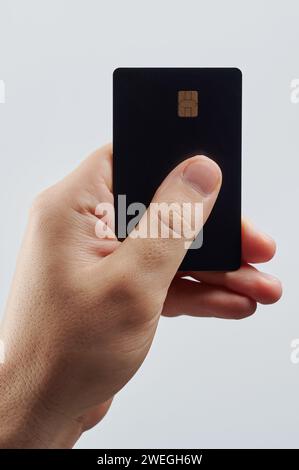 Hand hold black bank plastic card isolated on white studio background Stock Photo