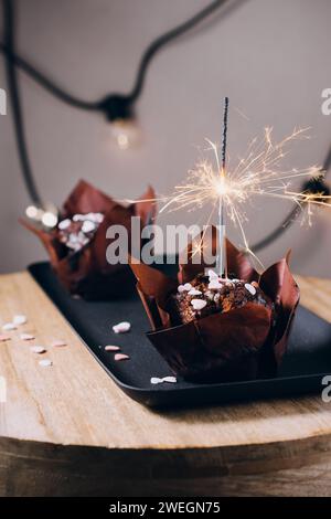 Chocolate muffins, cupcakes with sparklers for celebration. Stock Photo